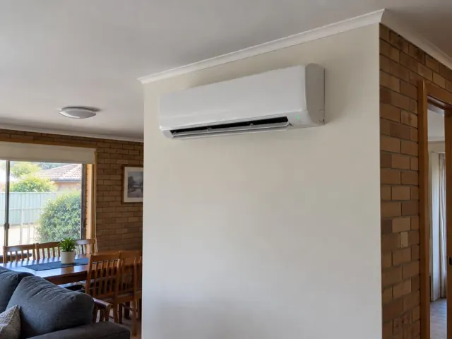 White split system indoor head on a cream wall in a brick home with louvre open in Aberfoyle Park